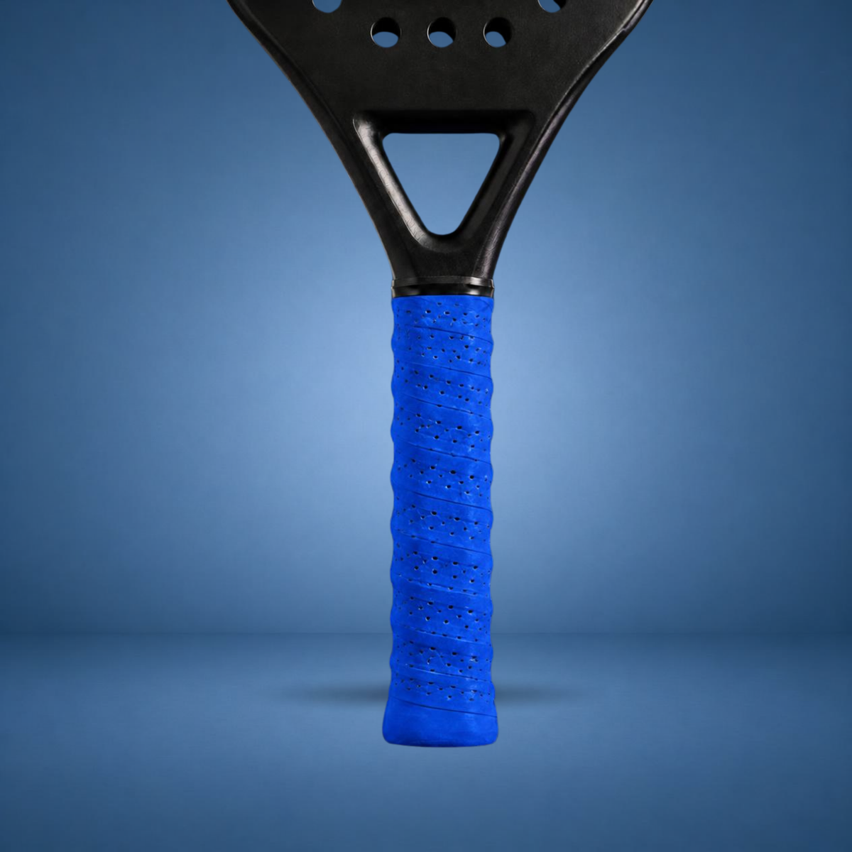 Surgrip perforé bleu sur un manche de raquette de padel, visuel studio sur fond bleu terrain (généré par IA)